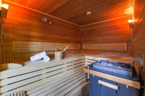 - un sauna avec une baignoire bleue et des murs en bois dans l'établissement AvenidA Mountain Lodges Kaprun, à Kaprun