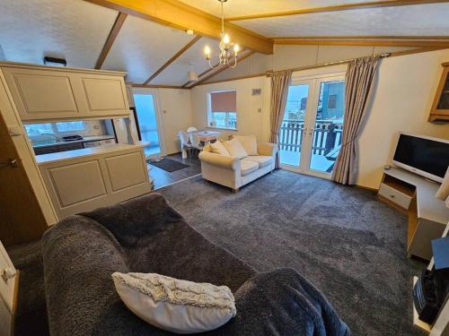a living room with a couch and a tv at Cozy rural lodge, amazing views close to Holmfirth in Holmfirth