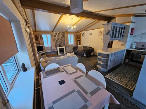 ein Wohnzimmer mit einem Tisch und ein Wohnzimmer mit einem Sofa in der Unterkunft Cozy rural lodge, amazing views close to Holmfirth in Holmfirth