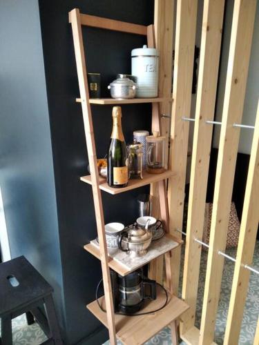 une étagère en bois avec une bouteille de vin dans l'établissement La Petite Amélie, à Aix-les-Bains