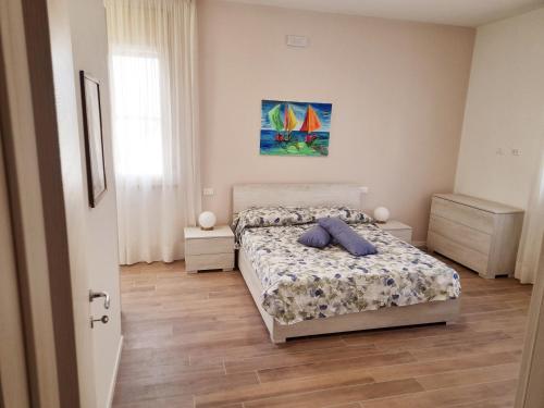 um quarto com uma cama e um quadro na parede em La Casera em Lido di Dante