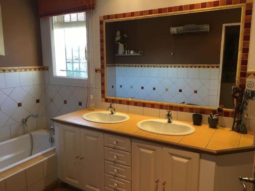 une salle de bain avec deux lavabos, une baignoire et un miroir dans l'établissement Villa piscine Gorges d'Ardèche, à Pont-Saint-Esprit