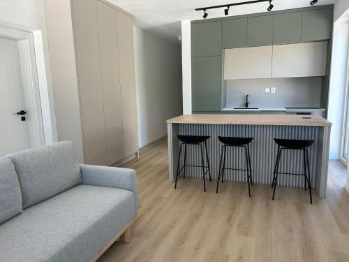a kitchen with a island with bar stools and a couch at Comfy Apartment Bojnice in Bojnice