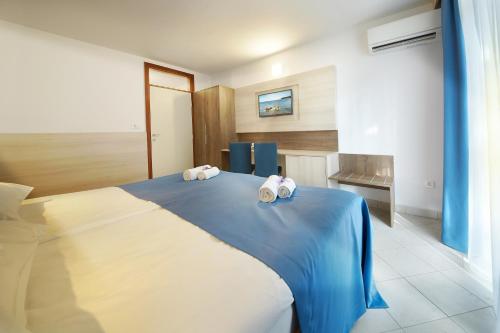a bedroom with a bed with two towels on it at Villa Bor - Hotel & Resort Adria Ankaran in Ankaran
