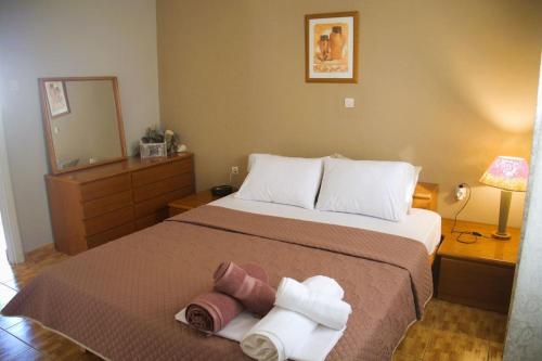 1 dormitorio con 1 cama con toallas en Xanthi's Summer House, en Vathí