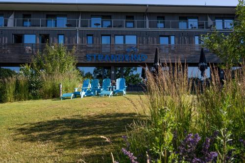 a group of chairs sitting in front of a building at Familotel Strandkind in Pelzerhaken