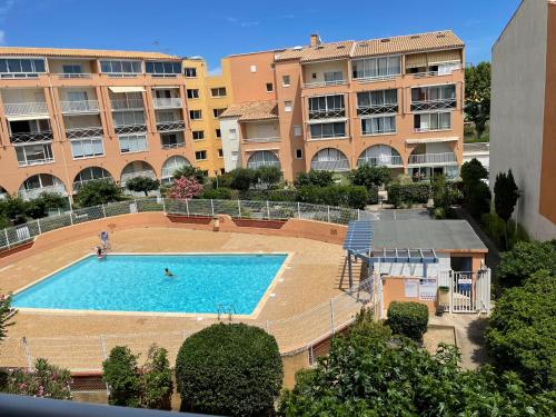 une grande piscine devant certains bâtiments dans l'établissement Résidence Antinéa - Grand appartement à 500 m des plages du Cap d'Agde, au Cap d'Agde