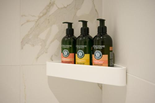 three bottles of wine sitting on a shelf in a bathroom at Petram Resort & Residences in Savudrija
