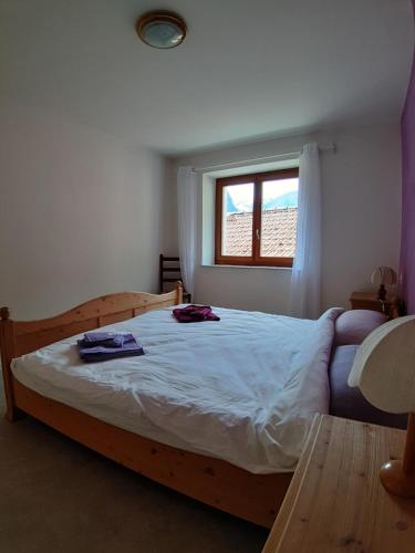 a bedroom with a large wooden bed with a window at Casa Allegra- appartamento Calla in Cavergno