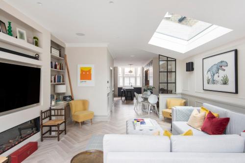 een woonkamer met witte meubels en een flatscreen-tv bij ALTIDO Spectacular house with private garden in Londen