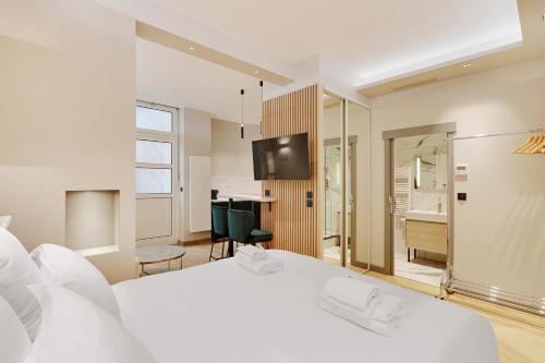 une chambre avec un grand lit blanc et un bureau dans l'établissement Pick A Flat's Apartment in Parc Monceau - Boulevard de Courcelles, à Paris
