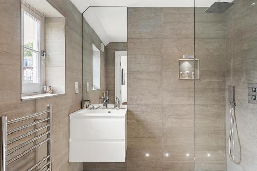 a bathroom with a sink and a shower at Veeve - Heart of Hampstead in London