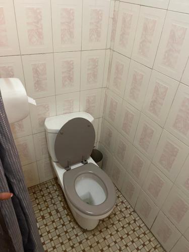 a bathroom with a toilet with the lid up at KM’s Cozy Spacious Calm Appart Meublé in Yaoundé