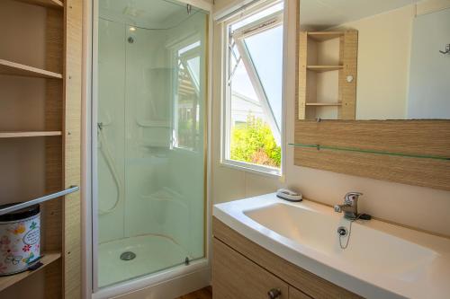 ein Bad mit einer Glasdusche und einem Waschbecken in der Unterkunft Mobil Home dans camping Frejus in Fréjus