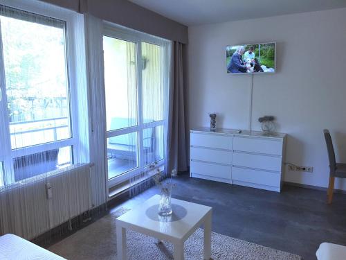 ein Wohnzimmer mit einer Kommode und einem TV an der Wand in der Unterkunft Alissa in Ludwigsburg