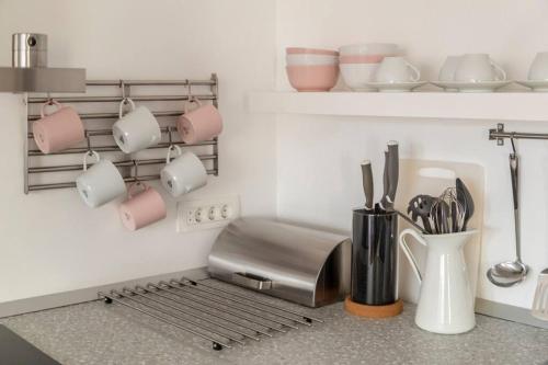 une cuisine avec un grille-pain, des tasses et des ustensiles dans l'établissement Ljubljana studio with FREE parking, Washer & Dryer, à Ljubljana