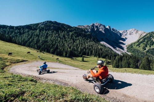 two people riding motorcycles on a dirt road at Appartement Alpenliebe in Bichlbach