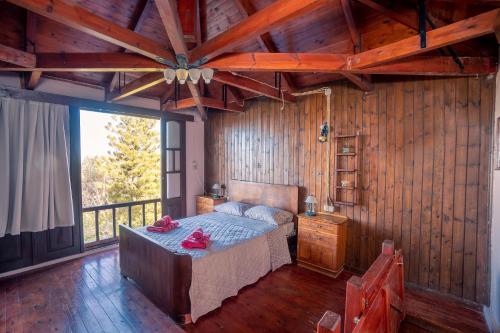 a bedroom with a bed and a wooden wall at Rustic Retreat in Tílisos