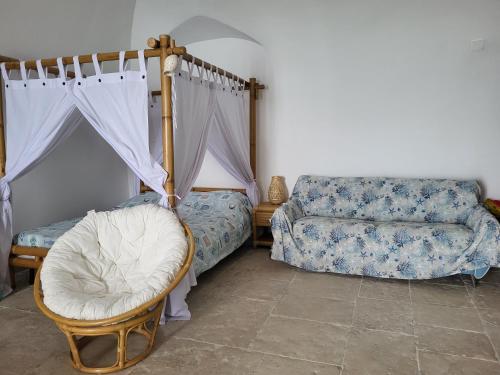 a bedroom with a bed and a chair and a couch at Nonna Libera Vista Mare in Rodi Garganico