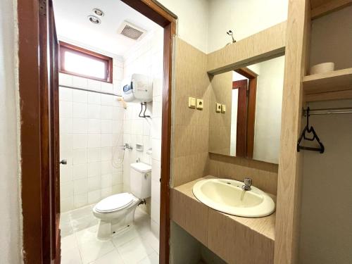 La salle de bains est pourvue de toilettes et d'un lavabo. dans l'établissement Hotel Winotosastro by Athelu, à Timuran