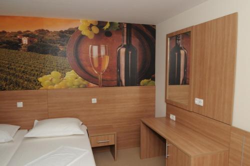 Schlafzimmer mit einem Gemälde von Weingläsern und einem Bett in der Unterkunft Guest House Ostojić in Međugorje
