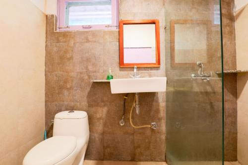 uma casa de banho com um WC, um lavatório e um espelho. em MANJARI RESORT em Tehri-Garhwāl