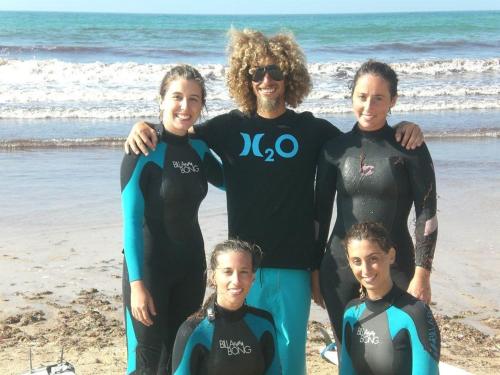 a group of people standing on the beach at H2O GuestHouse in Baleal