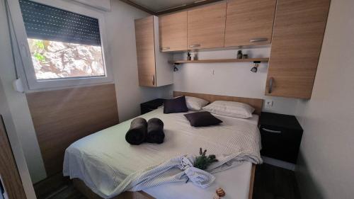 a small bedroom with a bed with two hats on it at Luxury Mobile Homes - Adria Superior in Klenovica