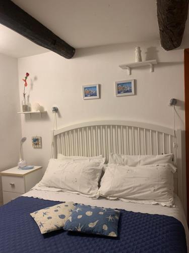 a bedroom with a bed with blue sheets and white pillows at CASABARBARA lerici in Lerici