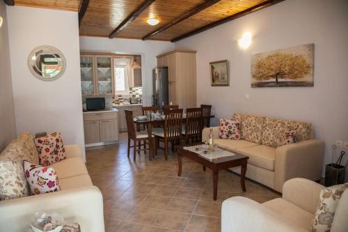 a living room with couches and a table and a kitchen at Irini's Traditional Kefalonian House in Lixouri