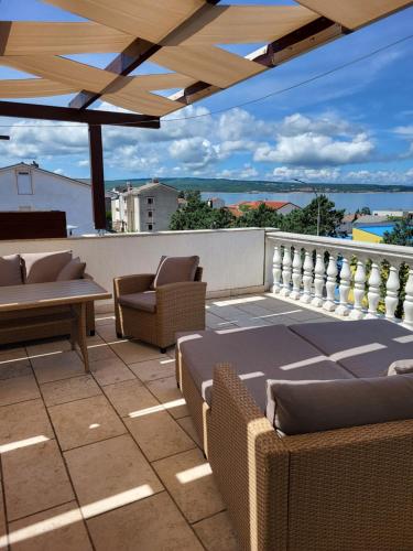 patio z krzesłami i stołami na balkonie w obiekcie Apartments Vukovic w mieście Selce