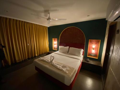 a bedroom with a large bed in a room with green walls at Gulf Hotel Mumbai- The Boutique Hotel Colaba Mumbai in Mumbai
