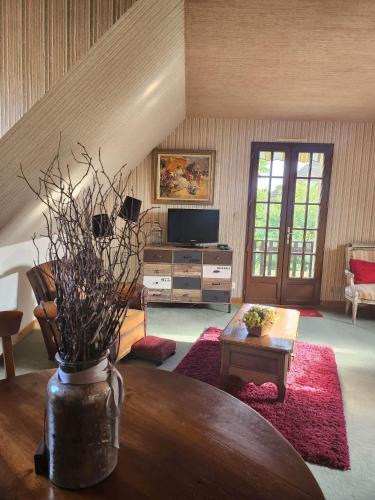 un soggiorno con tavolo e TV di Etage maison, accès indépendant a Le Mans