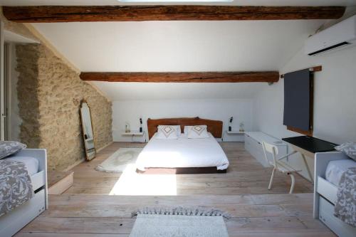 ein Schlafzimmer mit einem Bett und einem Schreibtisch in einem Zimmer in der Unterkunft Superbe Mas contemporain au pied du Luberon in Cheval-Blanc