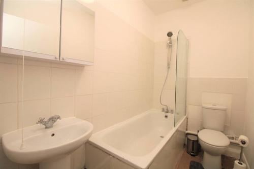 Baño blanco con lavabo y aseo en Ideal 2 Bed Flat close to City, en Londres