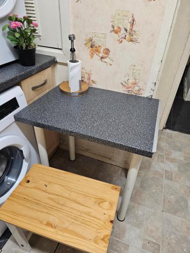 a table in a kitchen with a washing machine at Axel's Rooms 1 in Manchester
