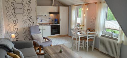 een woonkamer met een tafel en een keuken bij Nordsee Ferienwohnung Ost in Dornumersiel