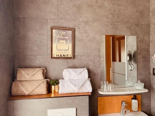 La salle de bains est pourvue d'un lavabo, d'un miroir et de serviettes. dans l'établissement Bed and Breakfast Otentik, à Zuienkerke