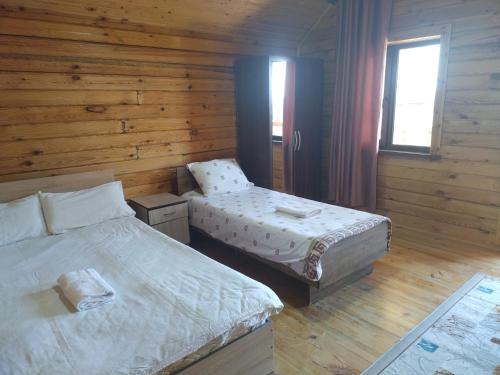 a bedroom with two beds in a wooden cabin at Пансионат Сабрина in Bosteri