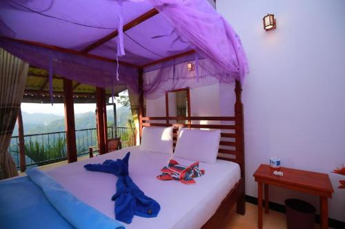 a bedroom with a bed with a purple canopy at Casa Ninearch Villa in Ella