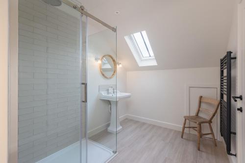 a bathroom with a glass shower and a sink at Angram Cottage in Thirsk