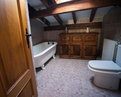 uma casa de banho com uma banheira, um WC e um lavatório. em Casa independiente con chimena, jardín y barbacoa em Santander