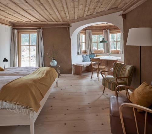 シェーナウ・アム・ケーニッヒスゼーにあるAlpeltalhütteのベッドルーム1室(ベッド1台、テーブル、椅子付)