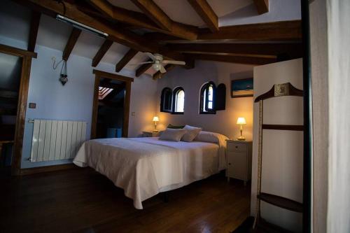 a bedroom with a bed in a room with wooden ceilings at Casa independiente con chimena, jardín y barbacoa in Santander