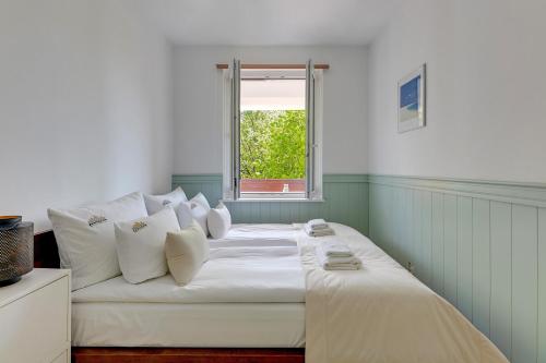 a white bed in a room with a window at Downtown Apartments Angielska Grobla Street in Gdańsk