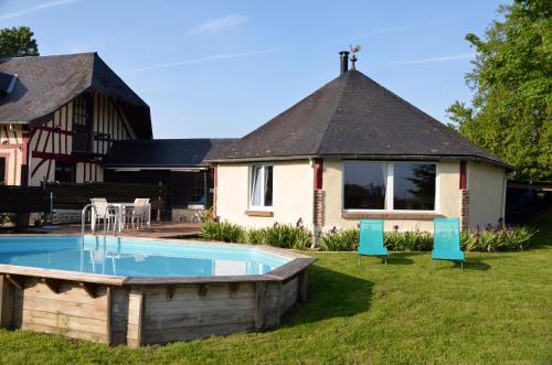 une maison avec une piscine dans la cour dans l'établissement Gîte le Manège Normand, à Grand Camp