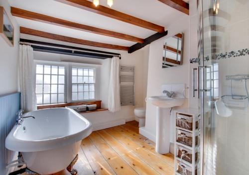 阿斯科里格的住宿－Rooks Cottage，浴室配有白色浴缸和水槽