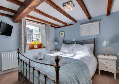 阿斯科里格的住宿－Rooks Cottage，一间卧室设有一张床、一台电视和一个窗口。