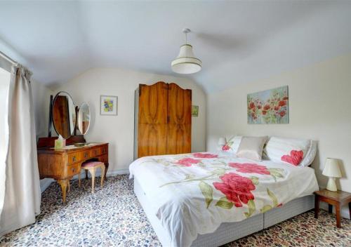 a bedroom with a bed and a dresser and a mirror at Rockley Cottage in Egton