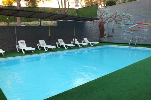 een zwembad met ligstoelen en een zwembad bij Avalon otel in Kuşadası